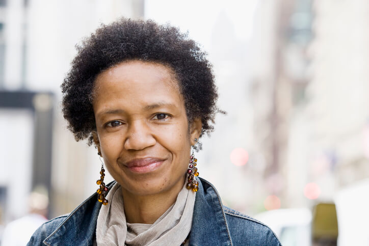 A middle-aged woman looks directly into the camera.